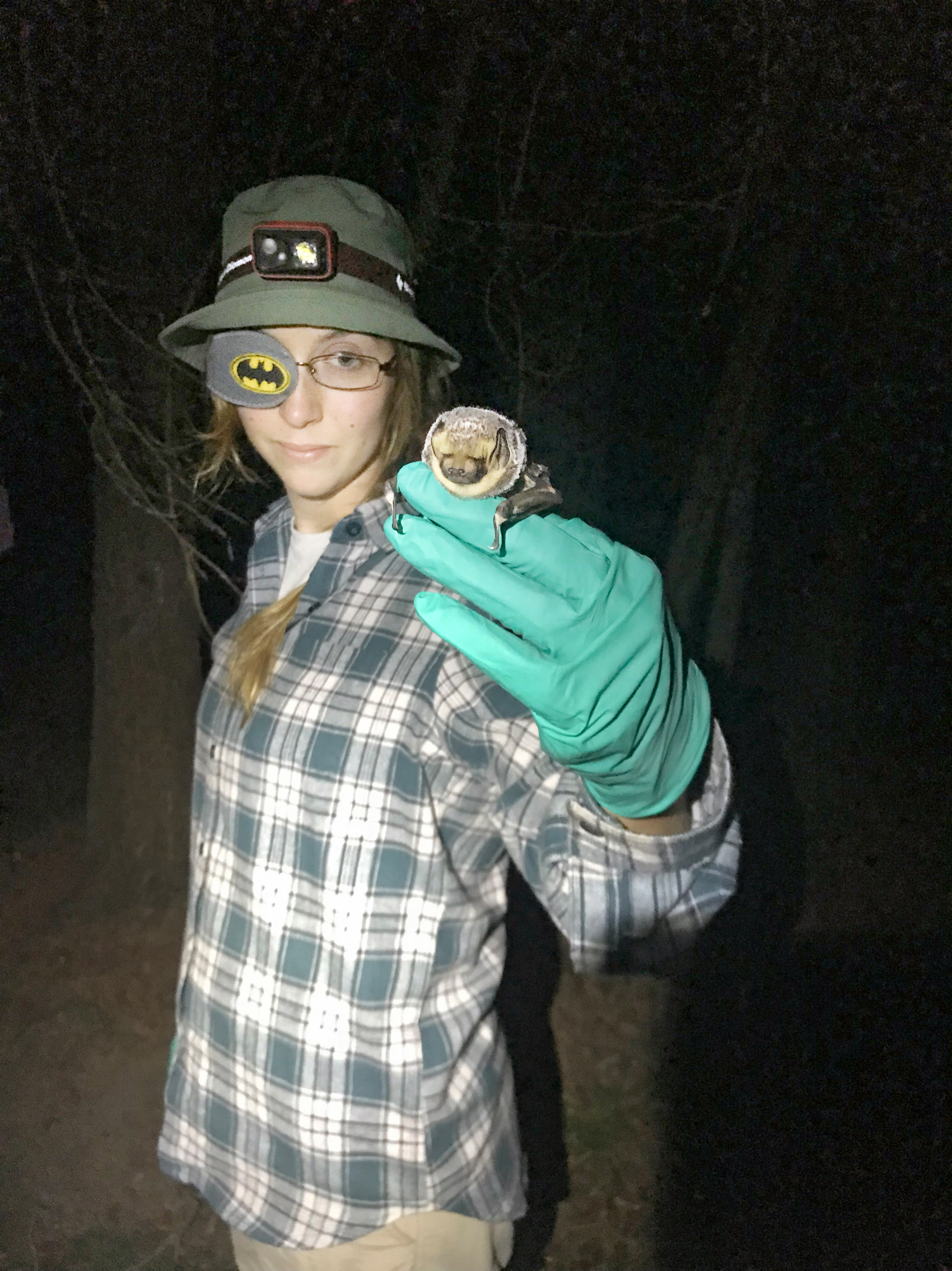 Dana Green stands with a hoary bat in her hand.