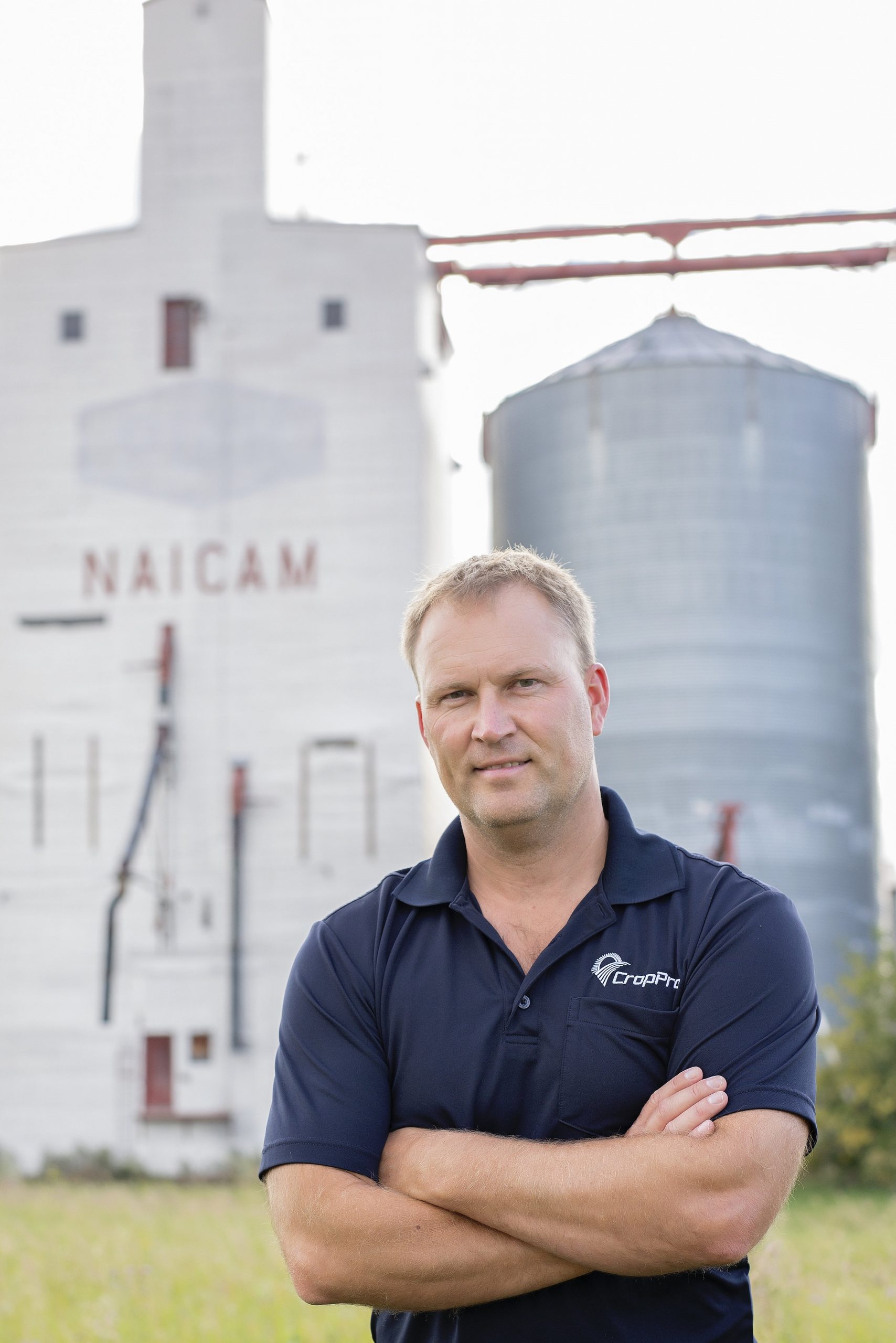 Cory Willness standing in front of a grain elevator.
