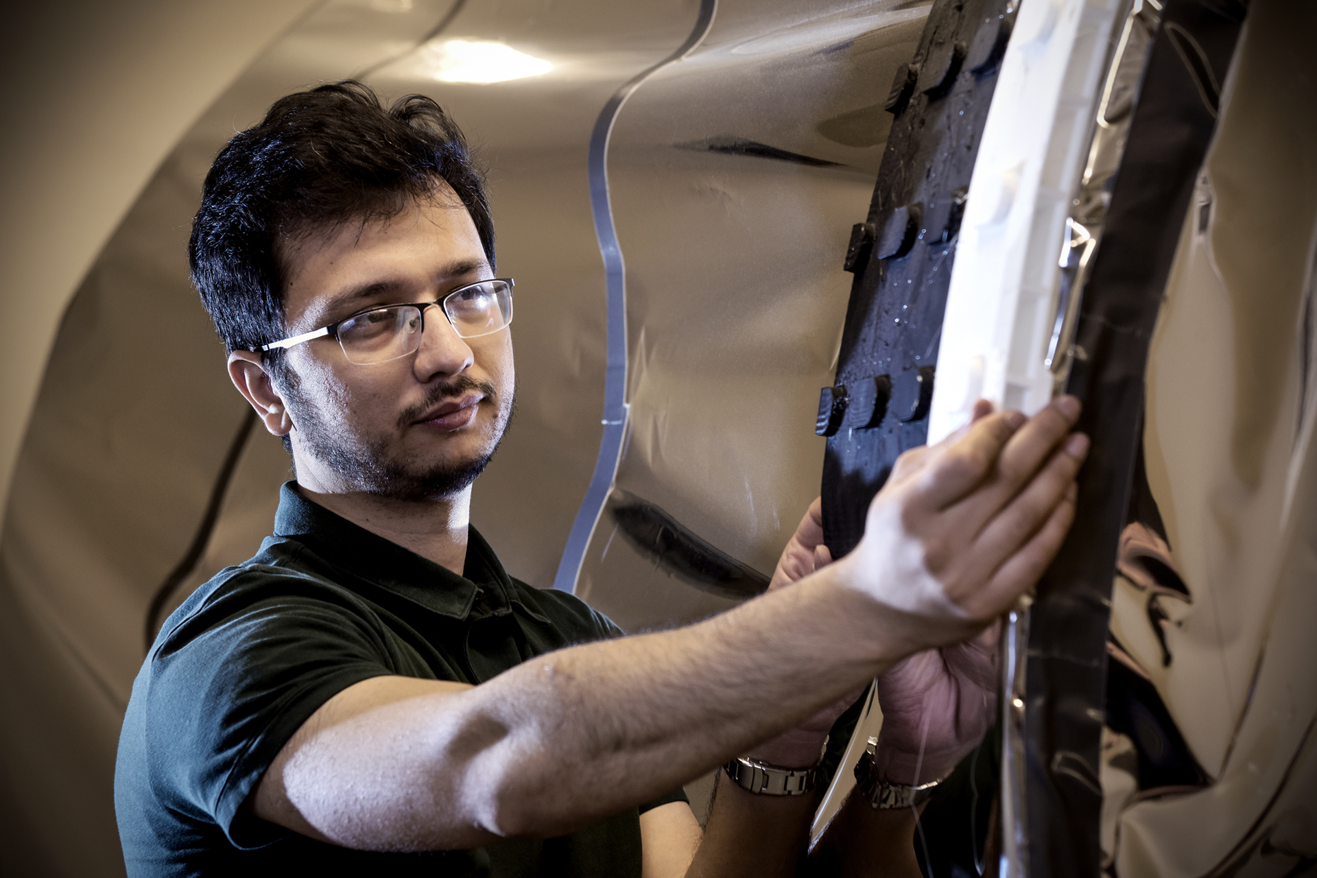 Anwit Adhikari fitting an endoskeleton he designed using a 3D printer onto the mock-up airlock. (Photo by Trevor Hopkin)