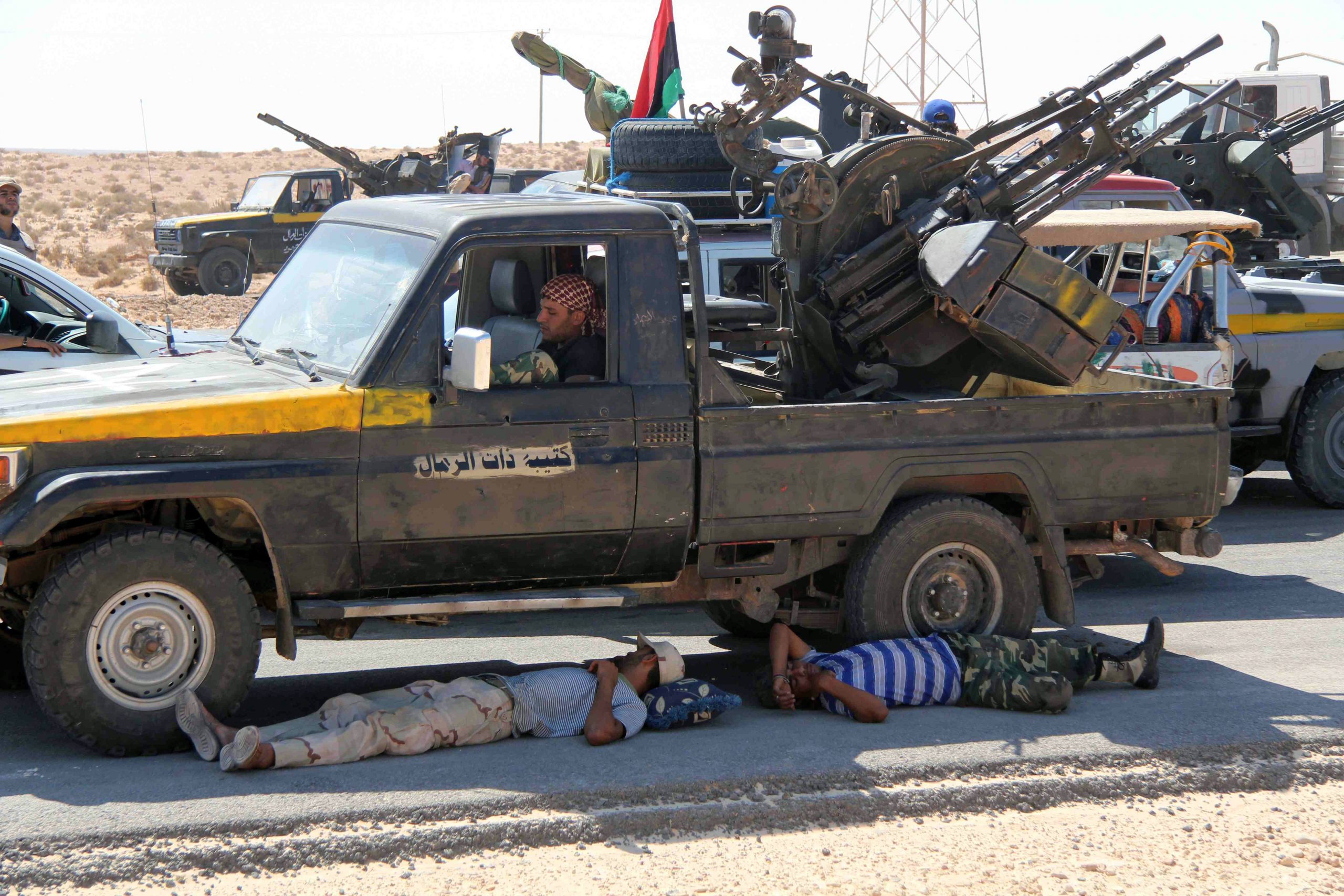 Insurgents escaping the sun while they wait for the signal for an attack outside Sirte, Libya. (Photo by Brian McQuinn)