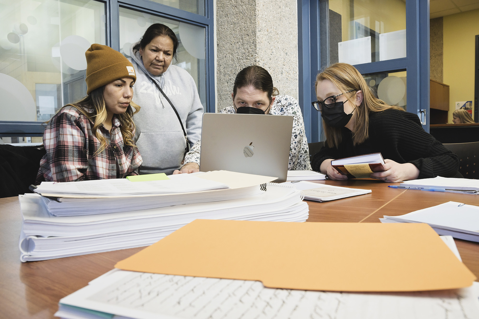 Nadine Obey, Barb Lavallee, Dr. Jérôme Melançon, and Véronique Mireault poring over documents from the former Marieval Indian Residential School. (Photo by Trevor Hopkin)