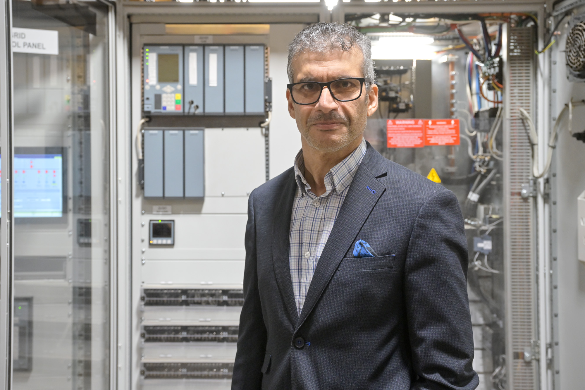 _URE5678 new Dr. Ifran Al-Anbagi, director of the Microgrid Living Lab and associate professor in the Faculty of Engineering and Applied Science, stands in front of the microgrid's control centre. (Photo by U of R Photography)