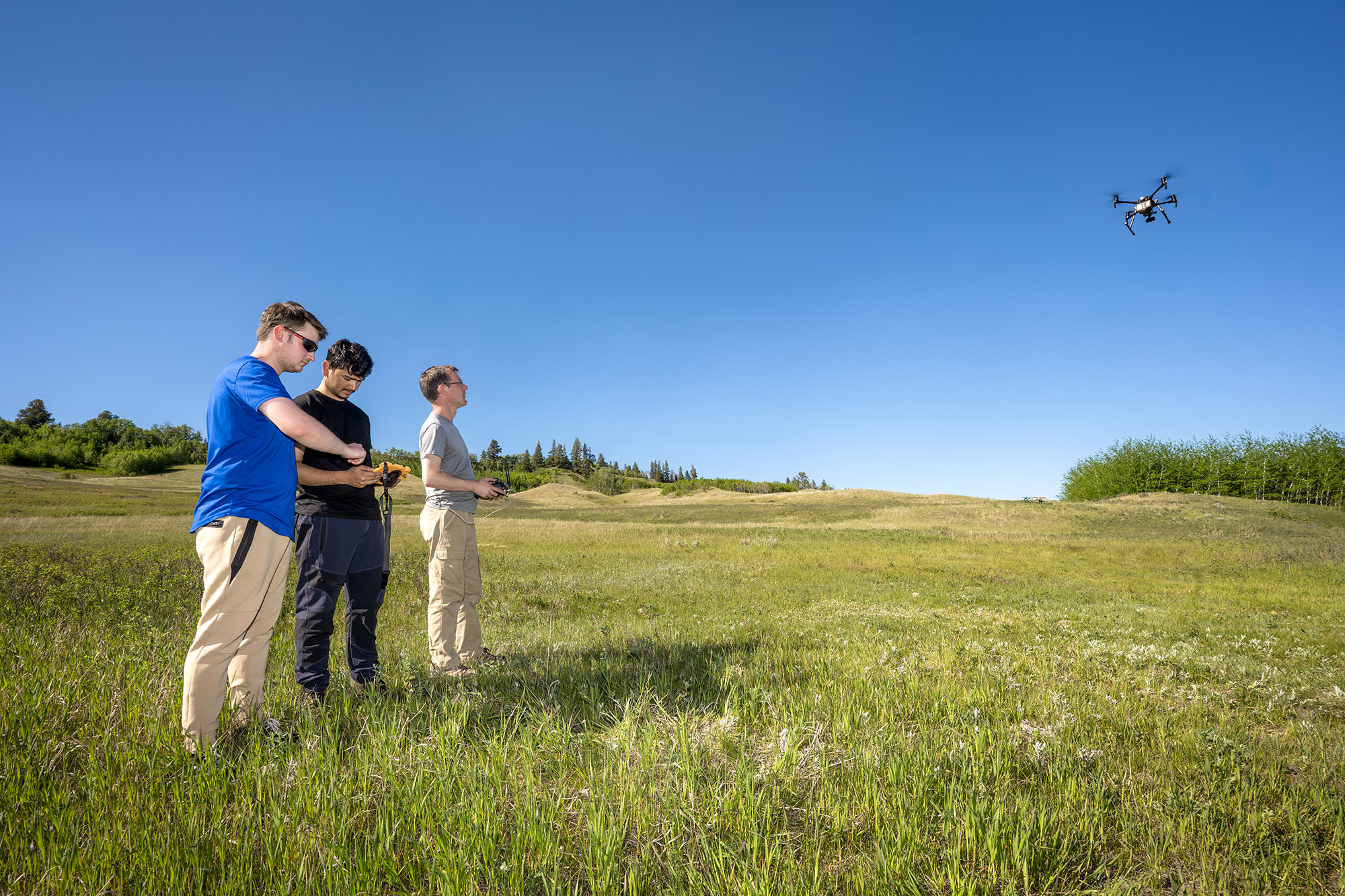 25-040-153 web Atom Yetowski, Dinesh Bhatta, and Dr. Mark Vanderwel flying the drone used to capture images of the trees in the Cypress Hills. (Photo by Trevor Hopkin)